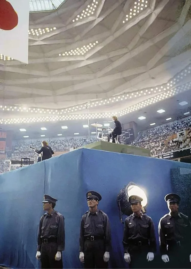 A concert photo of The Beatles breaking down barriers at Budokan in 1966.