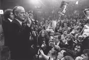A news photo showing Quebec Premier Rene Levesque on stage facing a crowd of enthusiastic "Oui" supporters during the first Quebec Referendum in 1980.